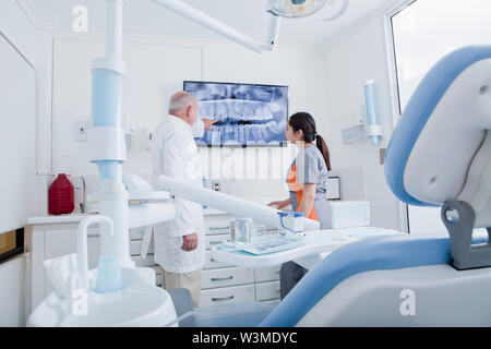 Dentist and dental hygienist examining X-ray on television screen Stock Photo