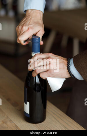 Hands of man opening bottle of wine Stock Photo