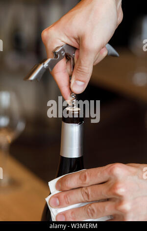 Hands of man opening bottle of wine Stock Photo