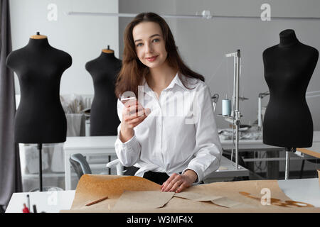 Fashion designer using smartphone in studio Stock Photo