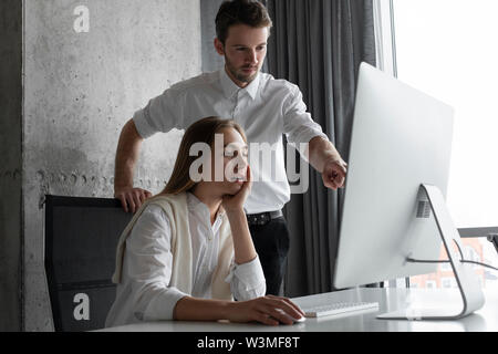 Businesspeople using computer together Stock Photo