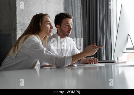Businesspeople using computer together Stock Photo