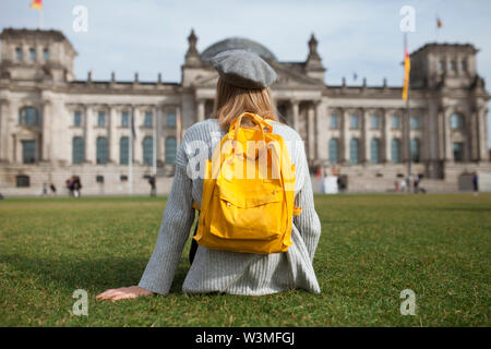 Young woman sitting in park by Reichstag in Berlin, Germany Stock Photo