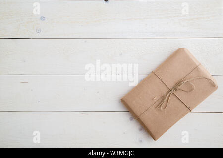 parcel,gift Packed in eco-friendly paper on light wooden background. the view from the top Stock Photo