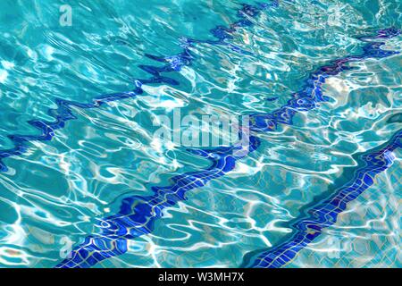 Abstract patterns formed by strong sunlight on the surface of water in a swimming pool  similar to  David Hockney's famous paintings Stock Photo