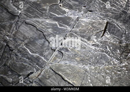 Slate surface with soft reflections of water. Stock Photo