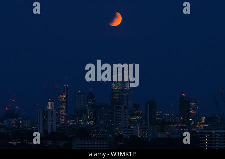 The 'Buck Moon' full moon rising over London. A partial lunar eclipse seen from Parliament Hill in Hampstead Heath, London, England, United Kingdom, UK Stock Photo