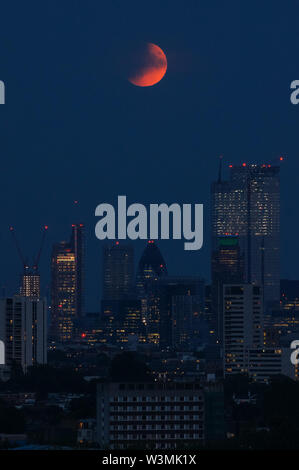 The 'Buck Moon' full moon rising over London. A partial lunar eclipse seen from Parliament Hill in Hampstead Heath, London, England, United Kingdom, UK Stock Photo
