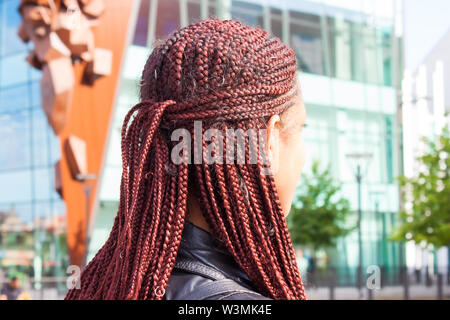 Girl with red braided hair style on street in summer. Stock Photo