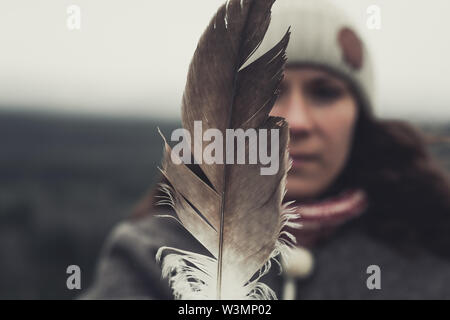 A young Woman shows an eagle's feather. Yukon Territory, Canada Stock Photo