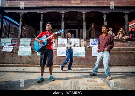 Life after the earthquake. Young men sing on the street to raise money for the victims in Panchadeval, Pashupatinath, Kathmandu. A 7.8 magnitude earthquake struck Nepal at 11:56 am, on 25th April, 2015, killing at least 7000 people. Kathmandu, Nepal. May 2, 2015. Stock Photo