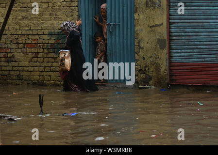 People facing troubles due to rainy water accumulated at China Scheme area as streets are presenting river view after the heavy monsoon rain in provincial. According to Met Department, heavy monsoon rain lashed Lahore and its adjoining areas in the wee hours of Tuesday. The incessant rain has flooded roads and streets in many parts of the city, rainwater entered houses in several low-lying areas of Lahore while parts of the city witnessed power outage as more that 150 Lesco feeders tripped soon after the rain started. Credit: PACIFIC PRESS/Alamy Live News Stock Photo