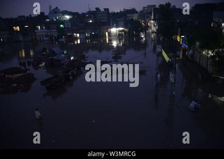 People facing troubles due to rainy water accumulated at China Scheme area as streets are presenting river view after the heavy monsoon rain in provincial. According to Met Department, heavy monsoon rain lashed Lahore and its adjoining areas in the wee hours of Tuesday. The incessant rain has flooded roads and streets in many parts of the city, rainwater entered houses in several low-lying areas of Lahore while parts of the city witnessed power outage as more that 150 Lesco feeders tripped soon after the rain started. Credit: PACIFIC PRESS/Alamy Live News Stock Photo