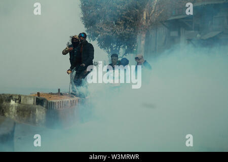 Protesters clash with indian paramilitary soldiers as intense tear smoke engulfs the old city srinagar.Kashmir on January 13,2018 government imposed restrictions in many parts of srinagar to foil pro freedom protest called by resistance leardership againest the killings of civilians by government forces during recent anti militancy operations. Stock Photo