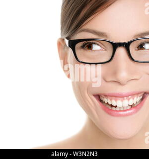 Woman wearing glasses looking happy to side. Eyewear woman with big smile wearing eyeglasses. Close up portrait of female spectacles model isolated on white background. Mixed race Asian Caucasian girl Stock Photo