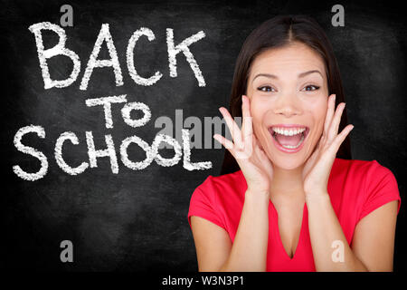 Back to School - university college student teacher screaming excited by blackboard with BACK TO SCHOOL written on chalkboard. Female student or funny woman teacher. Stock Photo