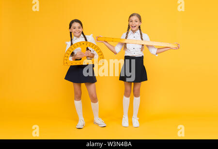 Explore world with math. Discover mathematics patterns. Mathematical theory combining algebraic and geometric methods. School students study geometry. Pupil school girls big rulers. School knowledge. Stock Photo