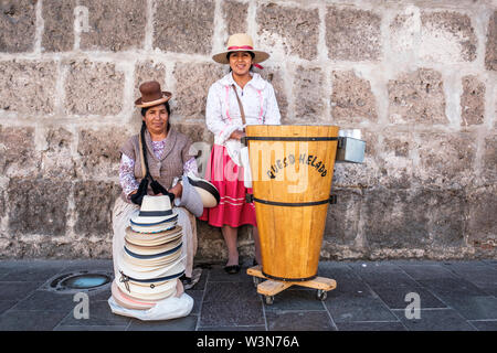 Street vendors. Portrait of Peruvian women selling queso helado (cheese ice cream) and hats dressed in traditional Peruvian clothing, Arequipa, Peru. Stock Photo