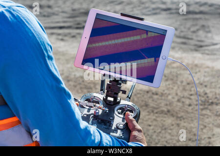 drone operator with remote control for a thermal UAV camera, surveying ...