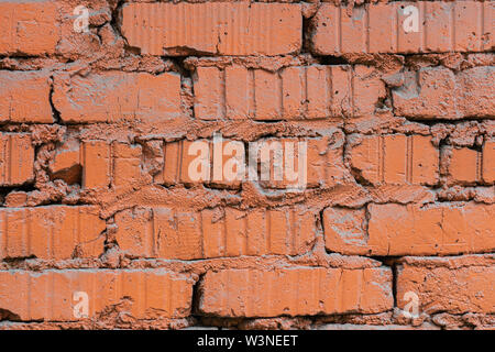 Closeup view of a grunge brick wall painted with orange paint. Texture or background for a project Stock Photo