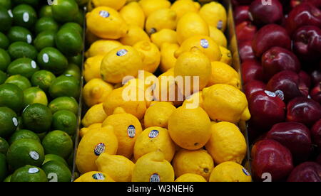 New London, CT / USA - June 2, 2019: Limes, lemons, and apples, lined up in the produce aisle
