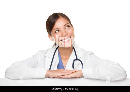 Beautiful young female doctor smiling while looking away isolated over white background Stock Photo