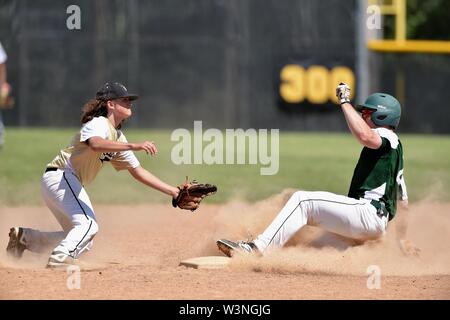 Runner sliding safely into second base with a steal as an infielder took a late throw from behind the bag. USA. Stock Photo