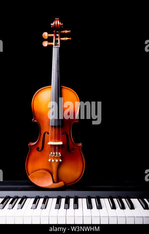 Violin on the piano on a black background Stock Photo