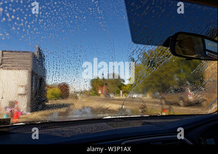 A car is being washed, there is water on the windscreen. Stock Photo