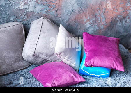 photo of gray soft sofa and purple pillows on it Stock Photo