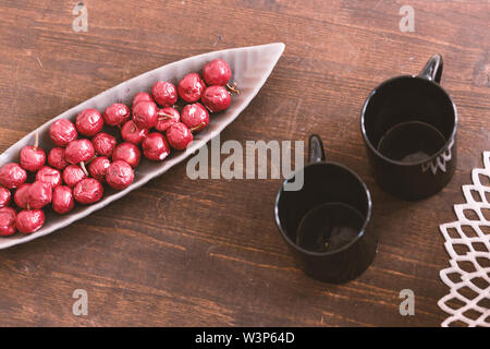 Photo of Table with two empty cups and artificial berries in a plate Stock Photo
