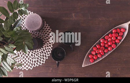 Table with two empty cups and artificial berries in a plate Stock Photo