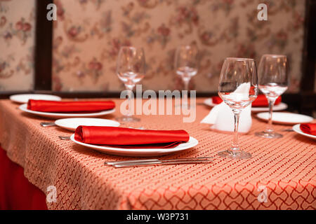 Table setting in the restaurant. Red tablecloths and napkins Stock Photo