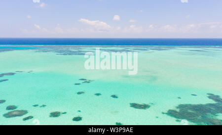 Sea water with lagoon and reefs, water background. Seascape with clear water. Large atoll with lagoon. Stock Photo