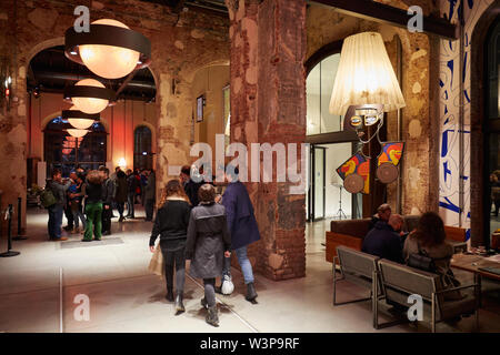 TURIN, ITALY - NOVEMBER 3, 2018: Ogr, Officine Grandi Riparazioni cafe interior with people, evening in Turin, Italy. Stock Photo