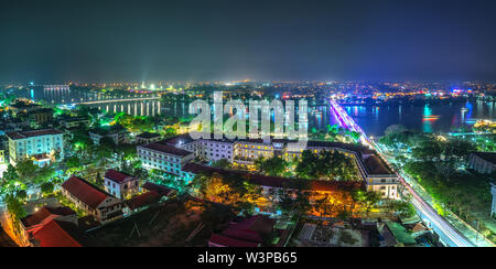 Panoramic city colorful night sparkling view from above in Hue, Vietnam. Stock Photo