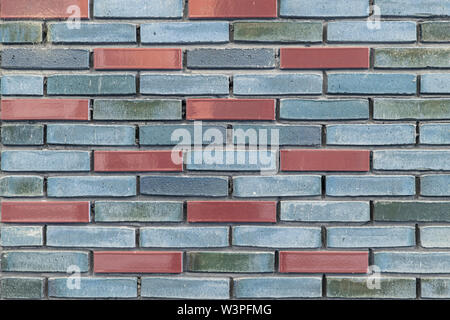 Blue and grey brick wall with a few brown colored bricks in it Stock Photo