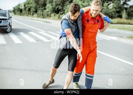 Medic In Uniform Helping Injured Man To Walk, Applying First Aid After ...