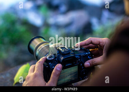 man holding camera in hand ready to take pictures in the nature Stock Photo