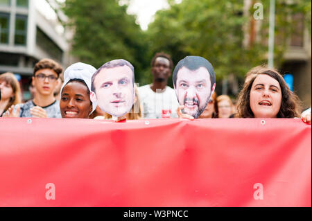 Barcelona, spain- 17 july 2019: young african and european women march holding banner and salvini and macron masks in  protest against immigration pol Stock Photo
