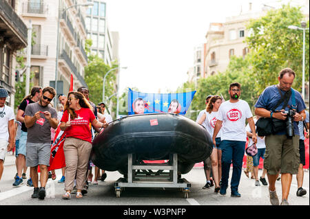 Barcelona, spain- 17 july 2019: young activists march holding rubber dinghy with european union flag and italian minister Salvini mask against immigra Stock Photo