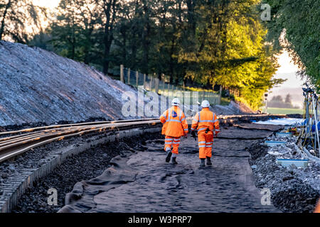 Railway workers constructing railway and lifting rail bridge into place Stock Photo