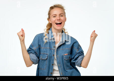 Woman holding fists up. Studio shot. Positiv facial human emotion. Stock Photo