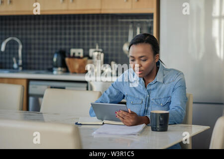 Young African American woman using a digital tablet at home Stock Photo
