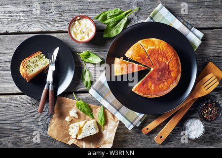 Green Bean spinach and blue cheese pie on a black plates with ingredients on a rustic wooden table, horizontal view from above, flat lay Stock Photo