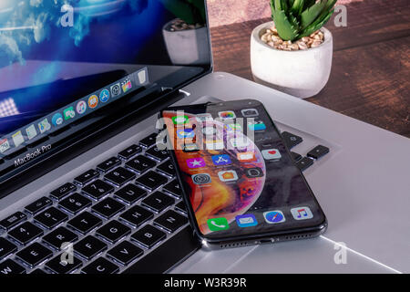 Galati, Romania- May 29, 2019: New iPhone Xs and Xs Max smartphone model by Apple Computers close up. Newest Apple iPhone on MacBook Pro 15 laptop key Stock Photo