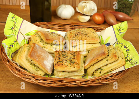 Fresh garlic bread rolls in wicker basket with decoration Stock Photo