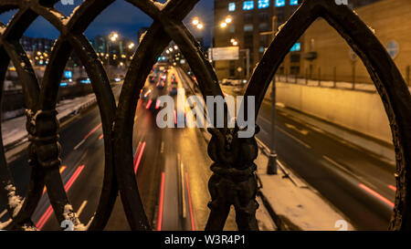 shot of the night traffic made through a cast-iron fence Stock Photo
