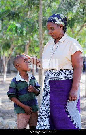 catholic catechist comfort a sad boy of Epiphany Pre- and Primary School in Bagamoyo, Tanzania, Africa Stock Photo