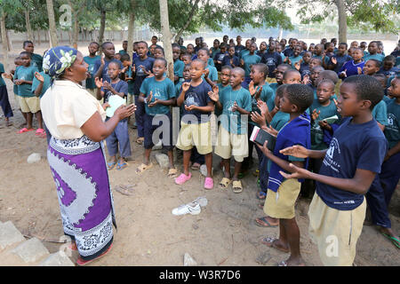 Catechist teaches catholic religion classes with students from Epiphany Pre- and Primary School in Bagamoyo, Tanzania Stock Photo